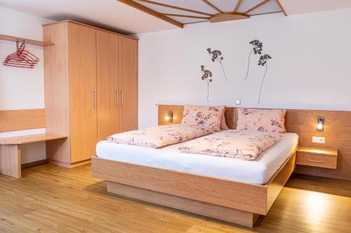 a bedroom with a bed with pink pillows at Haus Mandl in Mariapfarr