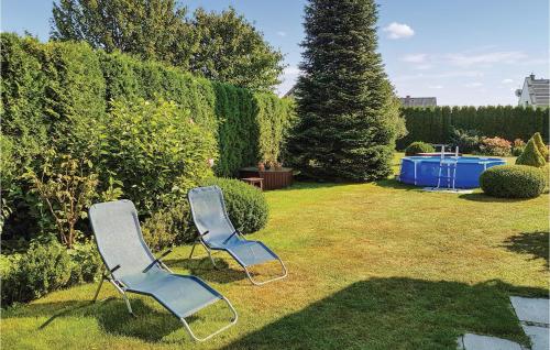 two blue chairs sitting in the grass in a yard at Stunning Home In Grzybowo in Grzybowo