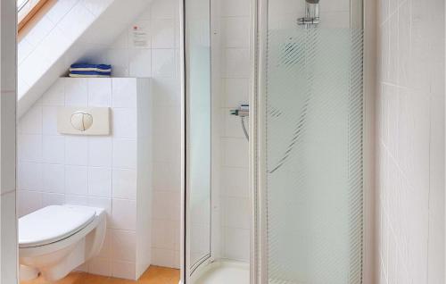 a bathroom with a toilet and a glass shower at Cozy Home In Grzybowo With Kitchenette in Grzybowo