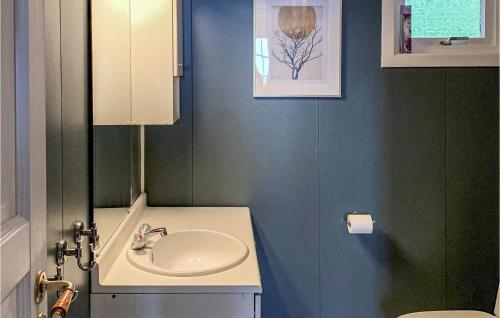 a bathroom with a sink and a toilet at Beach Front Home In Jondal With House Sea View in Jondal