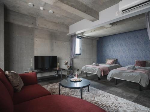 a living room with two beds and a tv at La luna in Yomitan