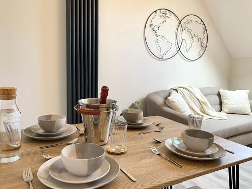 a living room with a wooden table with dishes on it at Luxury Scandi Inspired 1 Bed Town Centre Apartment in Bournemouth