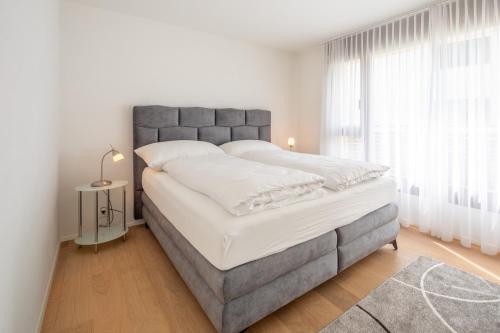 Una habitación blanca con una cama grande con sábanas blancas. en LAAX Homes - Casa Lanezzi 3, en Flims