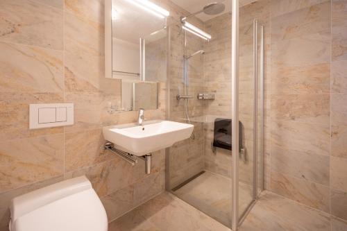 Un baño con inodoro, lavabo y ducha. en LAAX Homes - Casa Lanezzi 3, en Flims