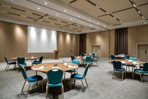 a conference room with tables and chairs and a projection screen at Novotel Istanbul Bosphorus Hotel in Istanbul
