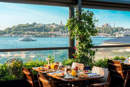 a table with food and a view of the water at Novotel Istanbul Bosphorus Hotel in Istanbul