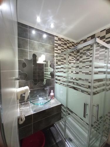 阿斯翠絲的住宿－Asterias Studios，一间带水槽和玻璃淋浴的浴室