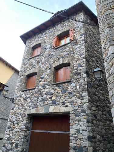 a tall stone building with windows and a door at Casa Conchita de Benasque in Benasque
