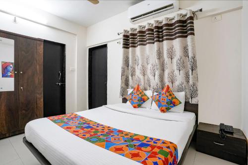 a bedroom with a bed and a curtain at FabHotel Vardhan House II in Dāpuri