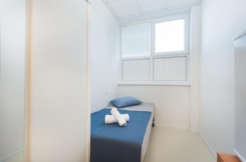 a small room with a bed with a window at Hostel Potpican in Potpićan
