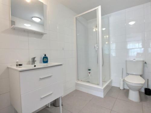 uma casa de banho branca com um chuveiro e um WC. em LE RIVIERA - Roissy CDG - Parc Astérix - Paris em Moussy-le-Neuf