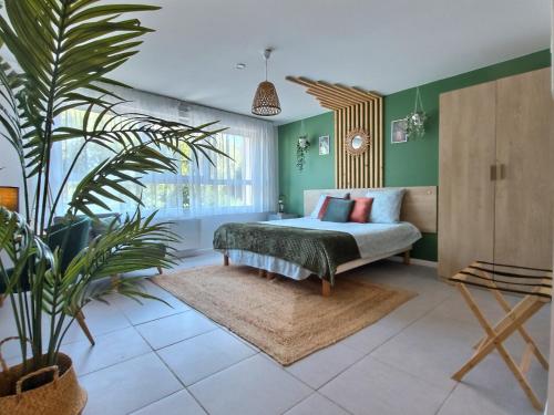 um quarto com uma cama e um vaso de plantas em LE RIVIERA - Roissy CDG - Parc Astérix - Paris em Moussy-le-Neuf