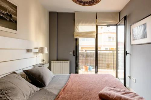 a bedroom with a large bed with a large window at Apt.p/5 15min from Barcelona and Beaches W/Terrace in Sant Adria de Besos