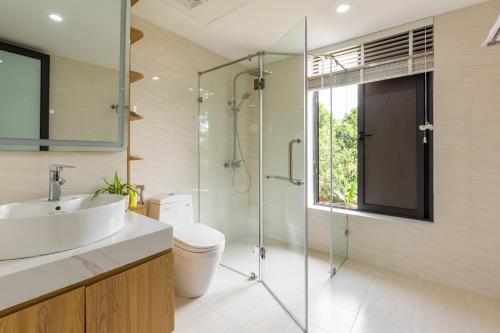 a bathroom with a sink and a glass shower at Phong Sơn Villa - Venuestay in Hanoi