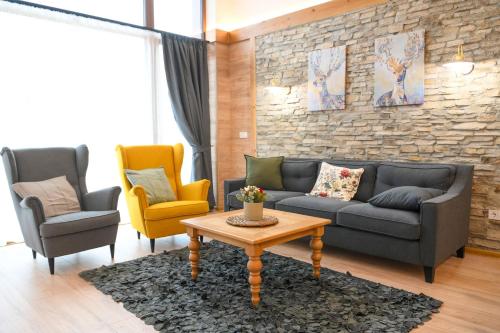 a living room with a couch and two chairs and a table at Villa Raphael near the Bansko Ski Resort in Razlog