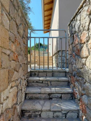 a stone stairway with a gate in a stone wall at Villa Avlaki in Vlikhon