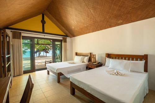1 Schlafzimmer mit 2 Betten und einem großen Fenster in der Unterkunft Virgin Beach Resort in San Juan