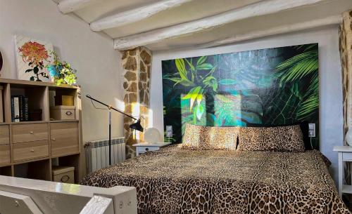 a bedroom with a bed with a large painting on the wall at Apartamento Romanov in Inogés