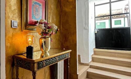 a vase with flowers on a table in a room at Apartamento Romanov in Inogés