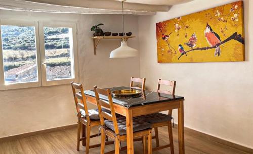 a dining room table with chairs and a painting on the wall at Apartamento Romanov in Inogés