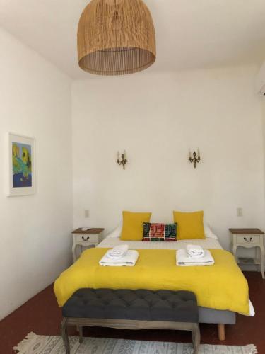 1 dormitorio con 1 cama amarilla y 2 toallas en Château la Sable, chambres d'hôtes en Cucuron