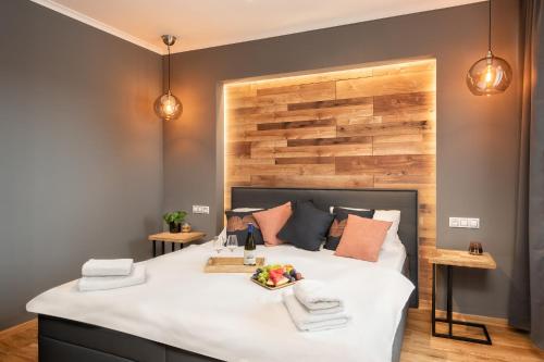 a bedroom with a large bed with a wooden headboard at Wine & Wellness hotel Besední dům in Valtice