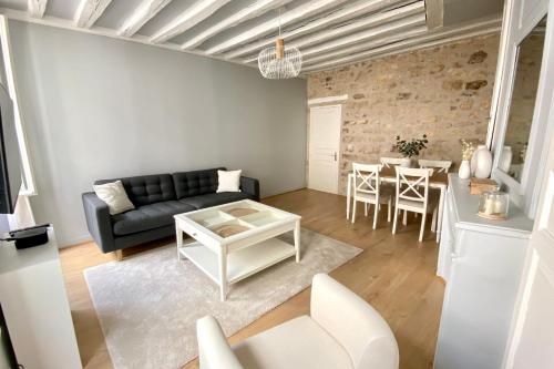 salon z kanapą i stołem w obiekcie Appart'Hôtel -Le Bellifontain w mieście Fontainebleau