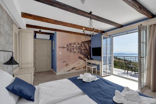 a bedroom with a bed and a view of the ocean at Heritage Hotel Liberan in Podgora