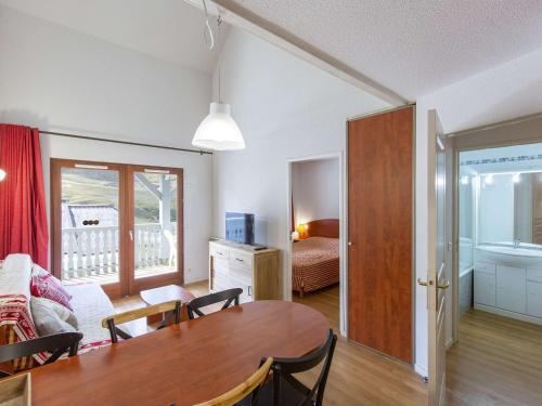 un salon avec une table et une chambre dans l'établissement Duplex cosy 7 pers. avec piscine, parking, à 400m des pistes - La Mongie - FR-1-404-248, à La Mongie