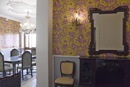 een eetkamer met een spiegel en een tafel bij Barocco al centro in Catania