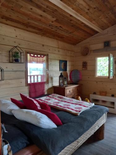 um quarto com uma cama num chalé de madeira em Chalet cocooning pleine nature em Montmorot