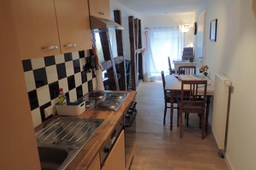 a kitchen with a stove and a dining table at Ferienwohnung Holzmaden Am Platz in Holzmaden