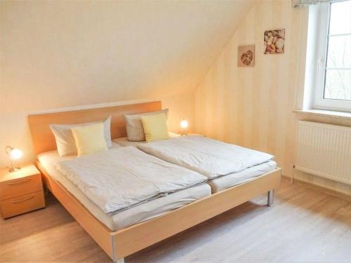 1 dormitorio con 1 cama grande con sábanas blancas y almohadas amarillas en Hus-Pellworm-2-Ferienwohnung-Meereswelle en Pellworm