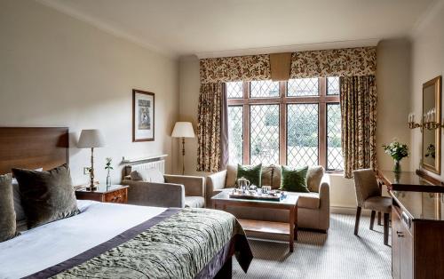 a hotel room with a bed and a living room at New Hall Hotel & Spa, Birmingham in Birmingham