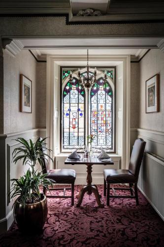 a room with a table and a stained glass window at New Hall Hotel & Spa, Birmingham in Birmingham