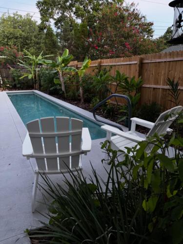 a pair of chairs sitting next to a swimming pool at Hollingsworth Guest House With Pool in Lakeland