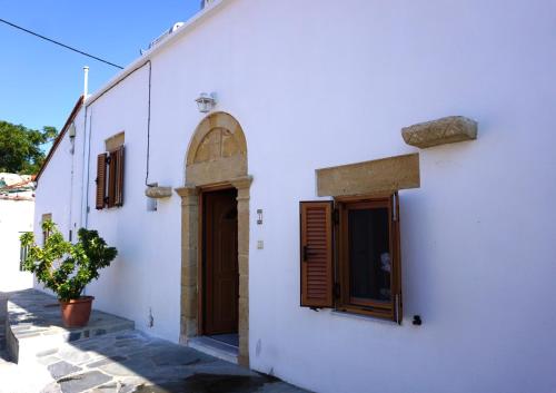 a white building with a door and a window at Amalia's Traditional Home in Paradisi in Paradeísion