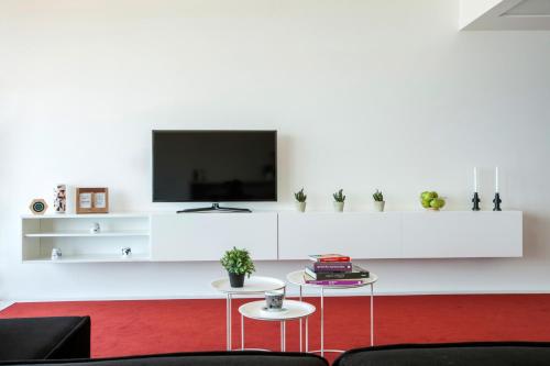 a living room with a tv on a white wall at 1866 Court & Suites Hotel in Beirut