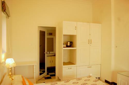 a white kitchen with white cabinets in a room at Aashray Homestay in Varanasi