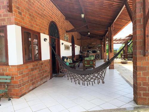 un patio al aire libre con una hamaca en un edificio de ladrillo en Casa de campo c vista para montanhas em Cha Grande, en Chã Grande