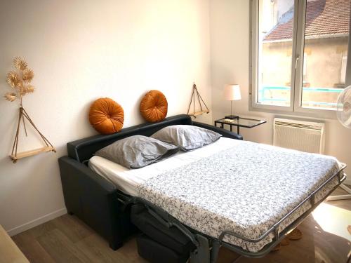 een slaapkamer met een bed met 2 kussens erop bij "Le Physalis" Élégant studio à 2 pas de Grenoble proche Tram in Fontaine