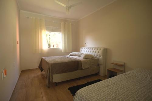 Un dormitorio con dos camas y una ventana. en Piscina e muito lazer em linda Chacara, Franca SP, en Franca