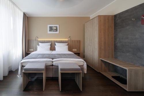 um quarto com uma cama grande e um armário de madeira em Hotel Jellentrup em Münster