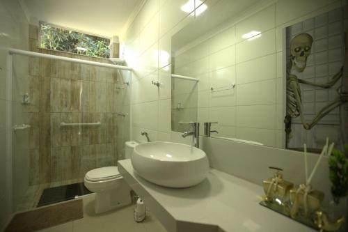 uma casa de banho com um lavatório e um crânio na parede em Piscina e muito lazer em linda Chacara, Franca SP em Franca