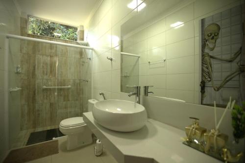 baño con lavabo y un cráneo en la pared en Piscina e muito lazer em linda Chacara, Franca SP, en Franca