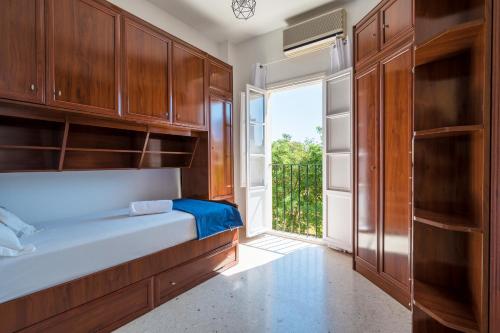 a bedroom with a bed and a large window at Sevillano apto en Centro cerca de Santa Justa in Seville