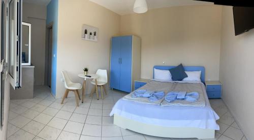 a bedroom with a bed and a table with chairs at Pame Apartments in Valanidorachi