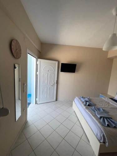 a bedroom with a bed and a door to the ocean at Pame Apartments Only Adults in Valanidorachi