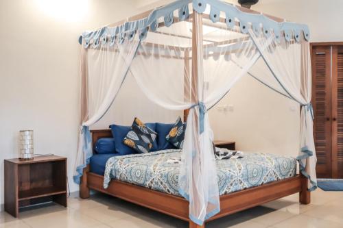 a bedroom with a bed with a canopy at Luz_ita Sunshine Villa in Uluwatu