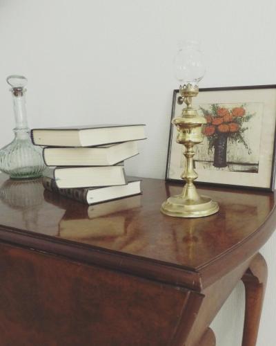 una mesa con libros y una lámpara y un jarrón en Gîte Maison Necty en Auvillar